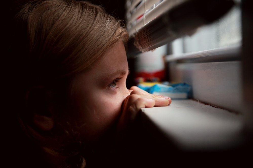 child looking out of window during Coronavirus lockdown
