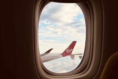 Window of an airplane looking outside to the airport