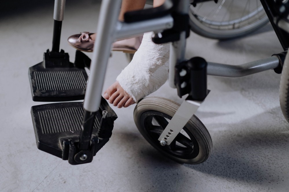 girl foot in plaster on a wheelchair